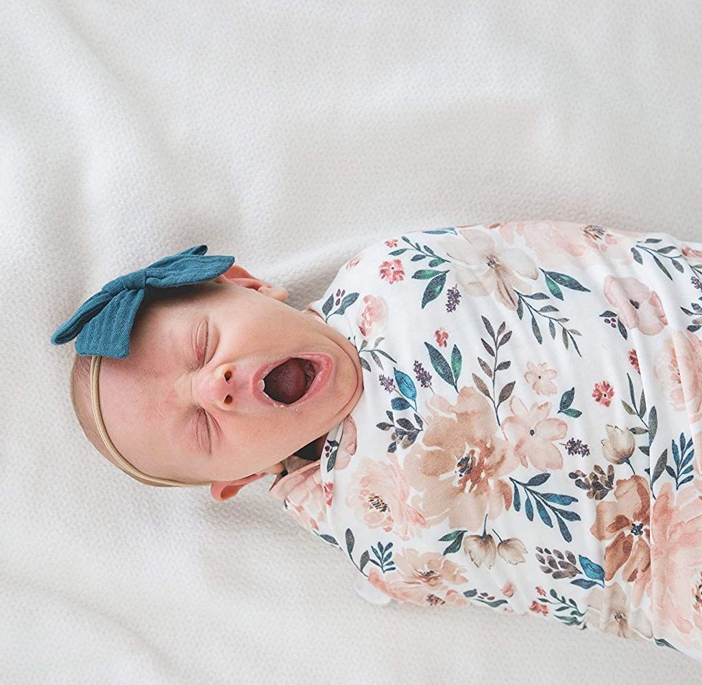 baby in swaddle blanket yawning