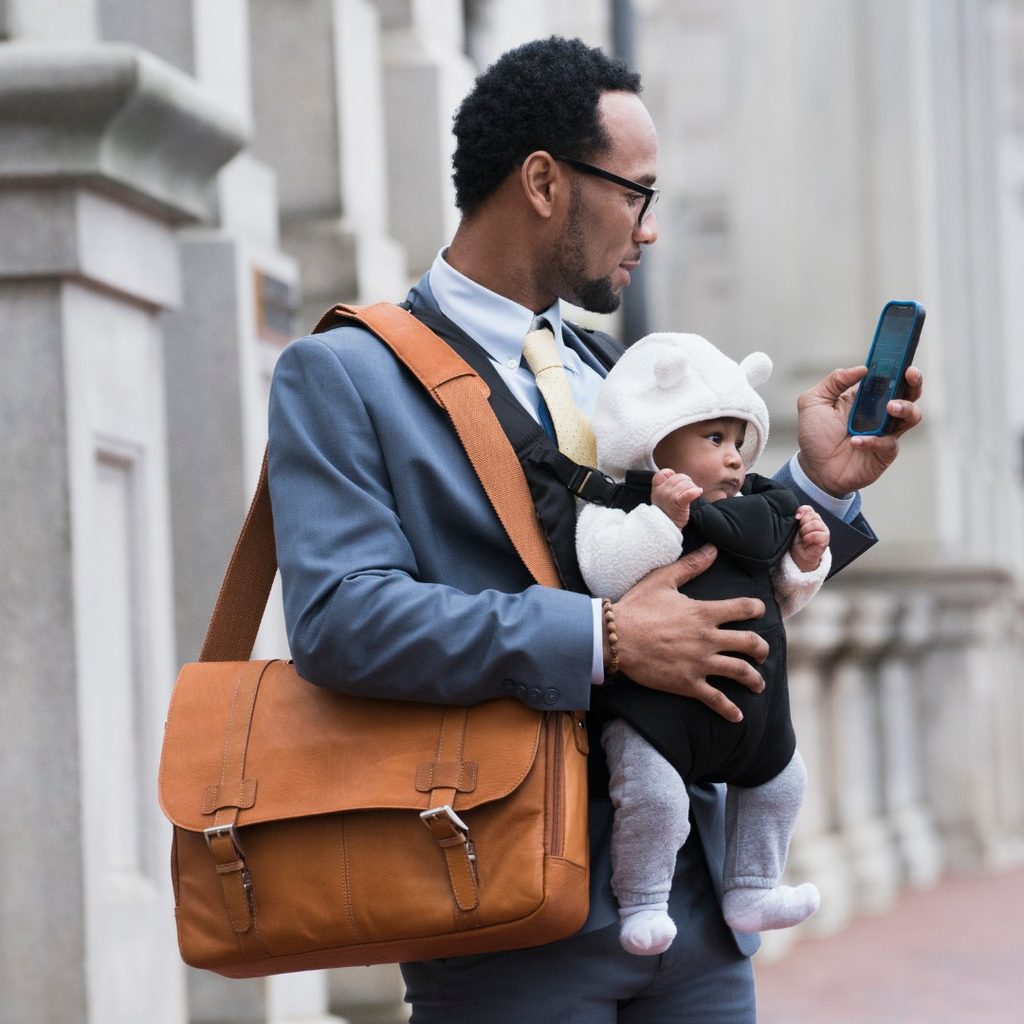 Man with baby, bag, and phone