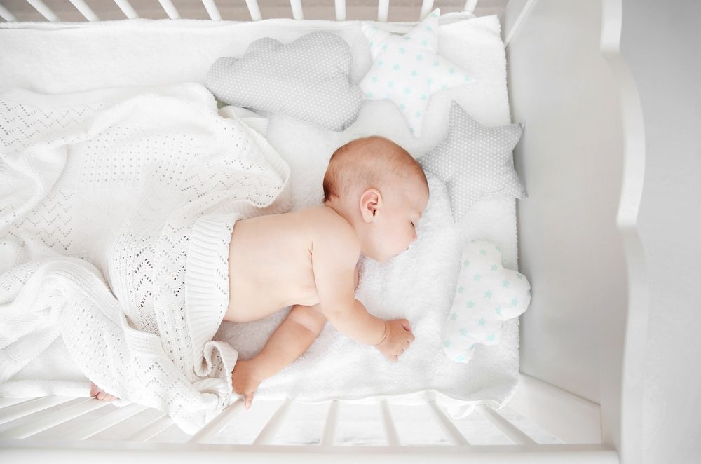 baby sleeping in white crib