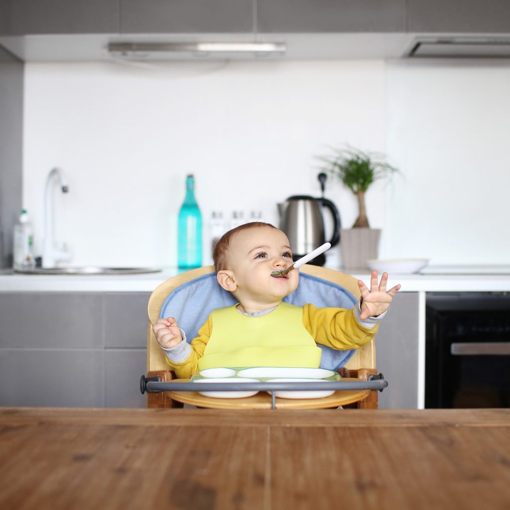 Baby sitting in high chair at table