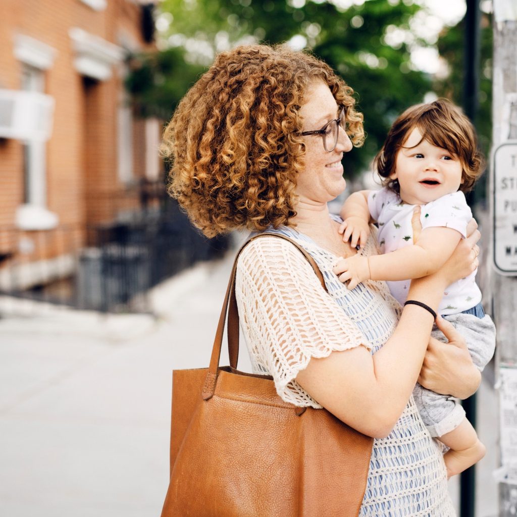 Adult carrying child and bag