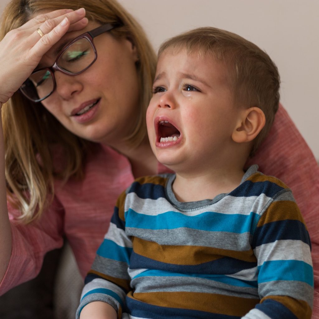 Crying child with tired mother