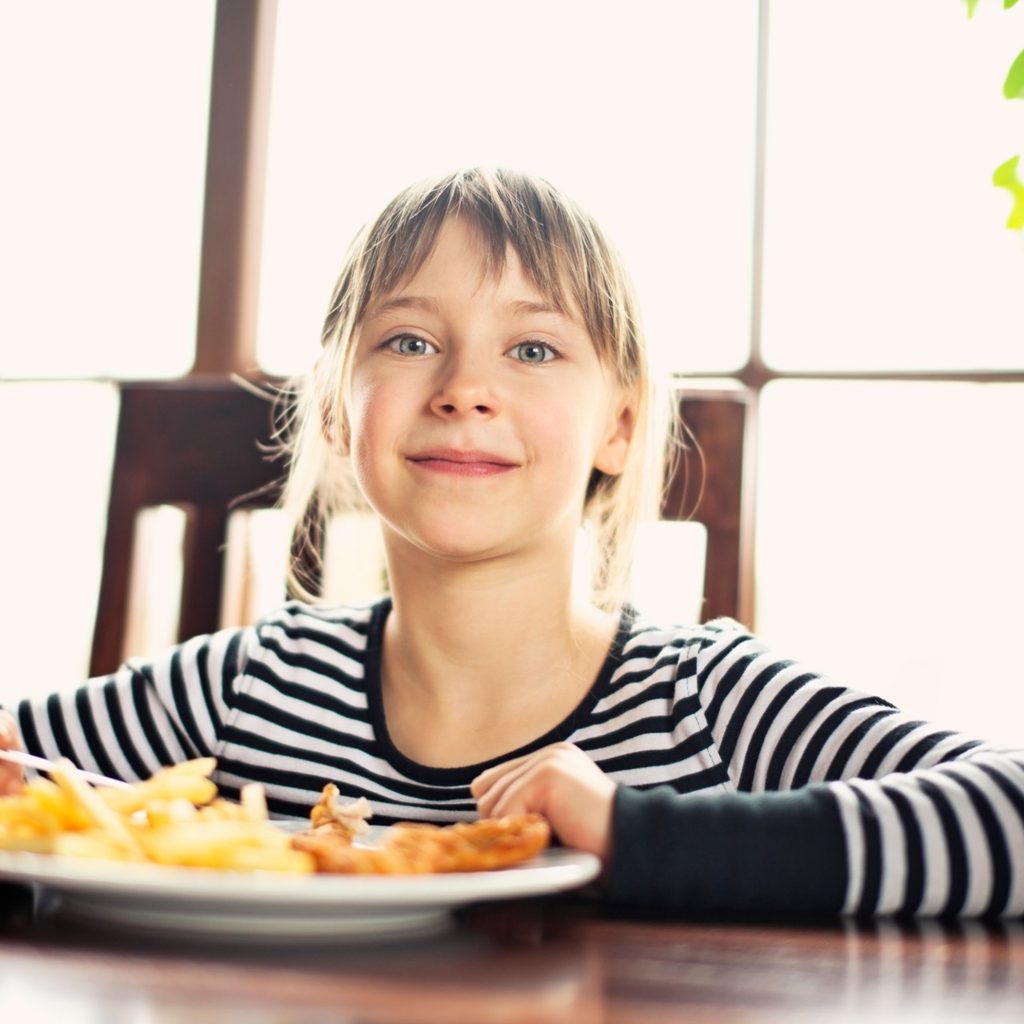 Young girl at table with takeout meal