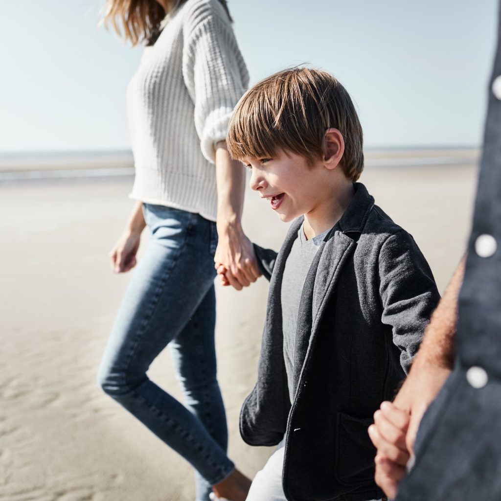 Boy walking with his parents