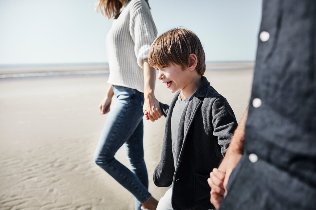 Boy walking with his parents