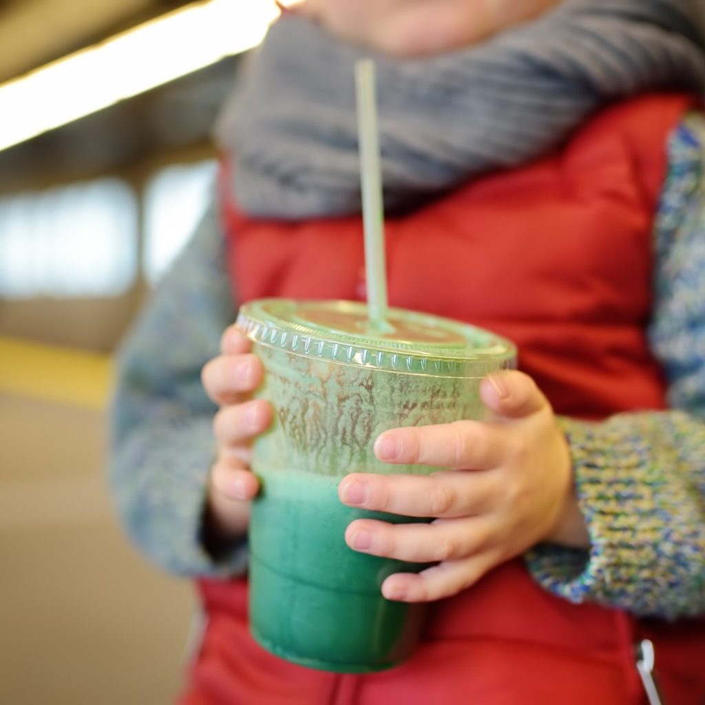 Child holding a fruit smoothie