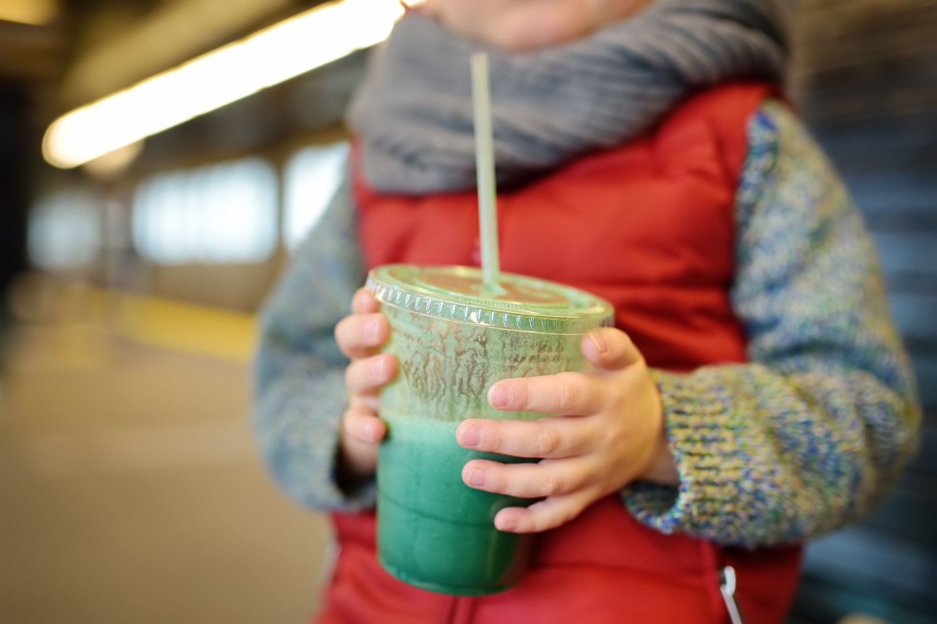 Child holding a fruit smoothie