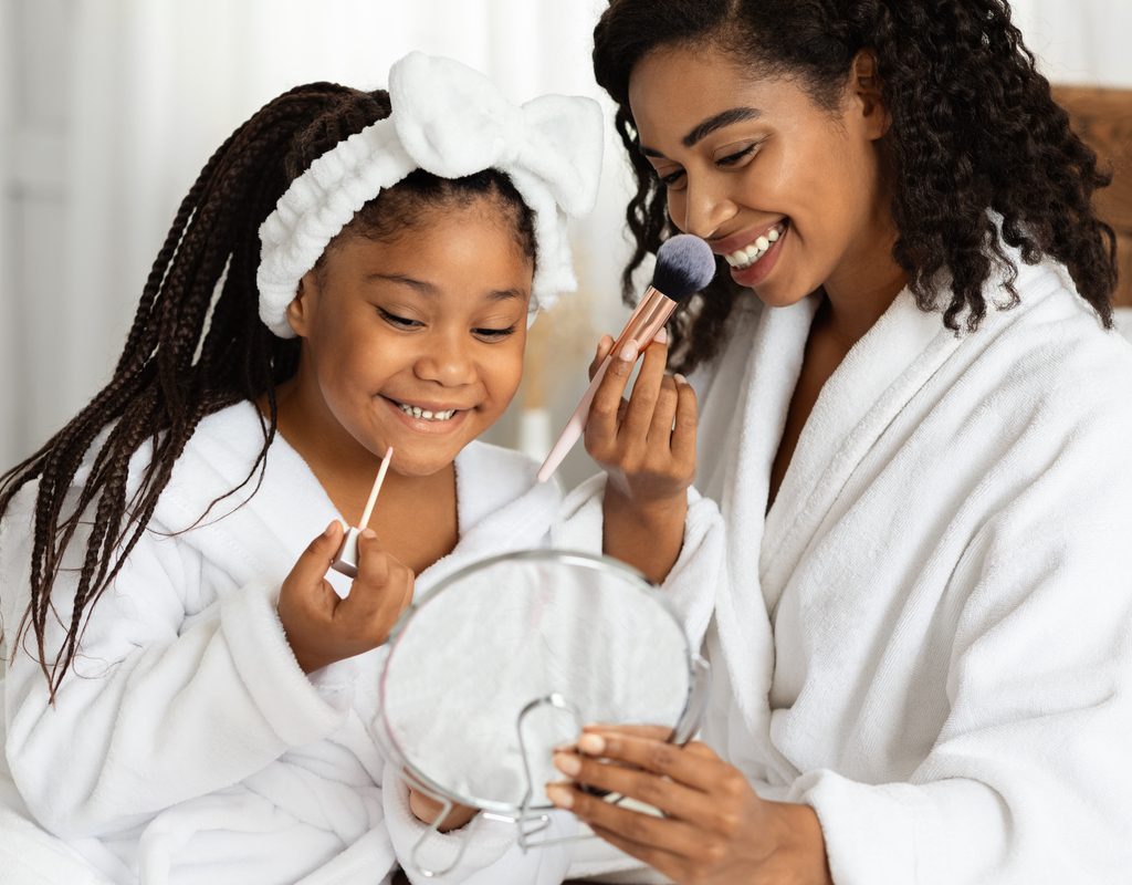 A mother and young daughter having a pampering makeup time