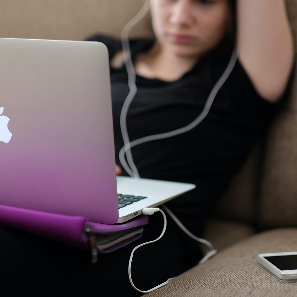 Teenager on couch using laptop computer