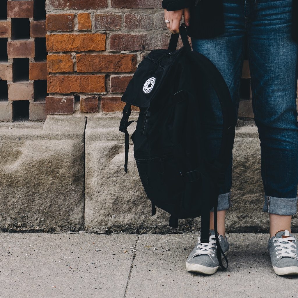 shot of student's jeans, sneakers and backpack