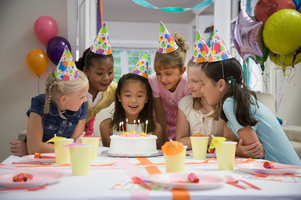 Young girls celebrating a birthday with cake