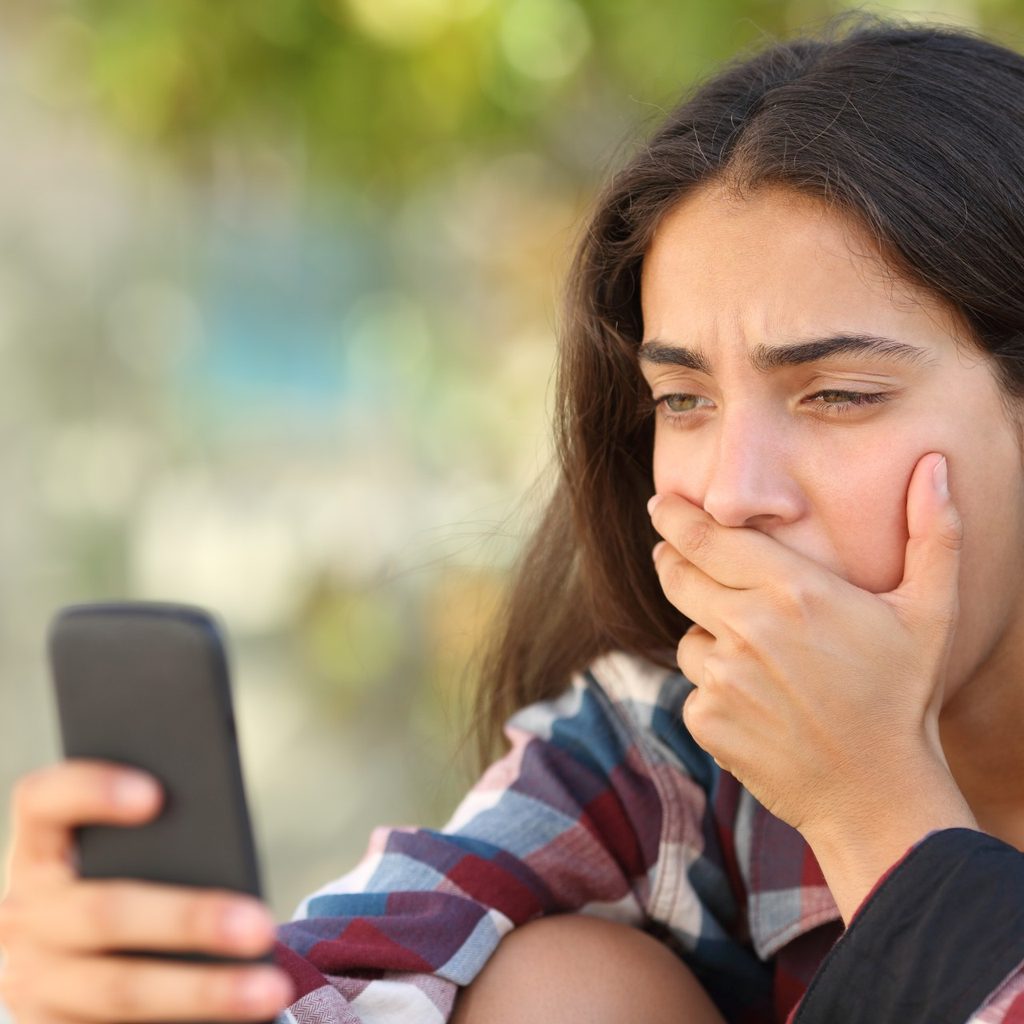 Teenage girl using smartphone outside