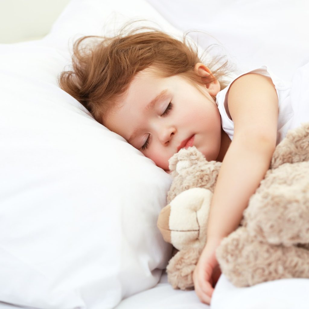 Toddler girl sleeping with plush bear
