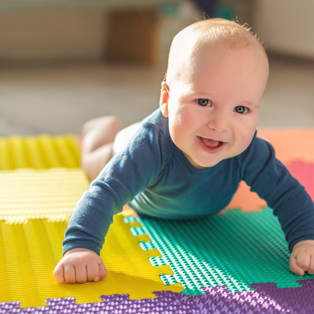 Smiling baby on colorful play mat