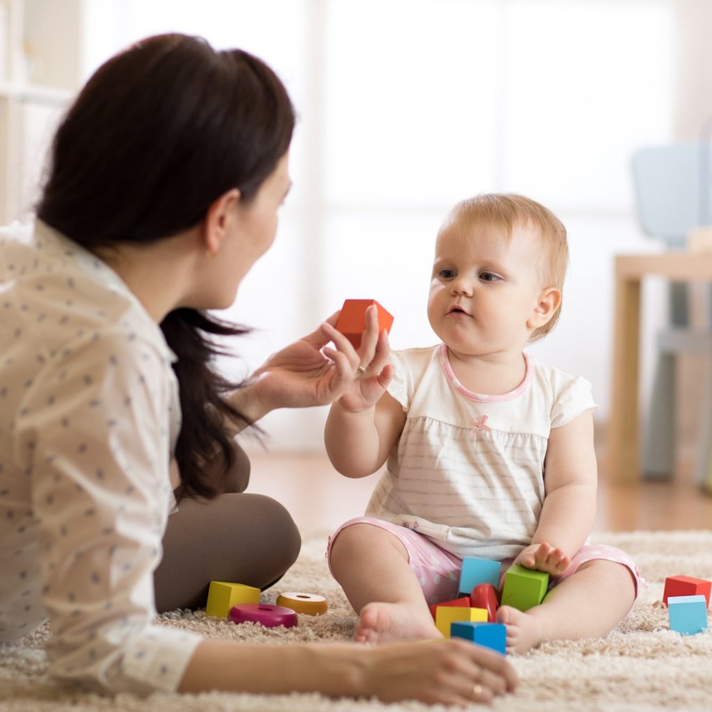 Mother with child playing with building blocks