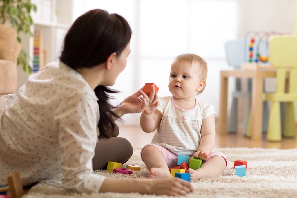 Mother with child playing with building blocks.