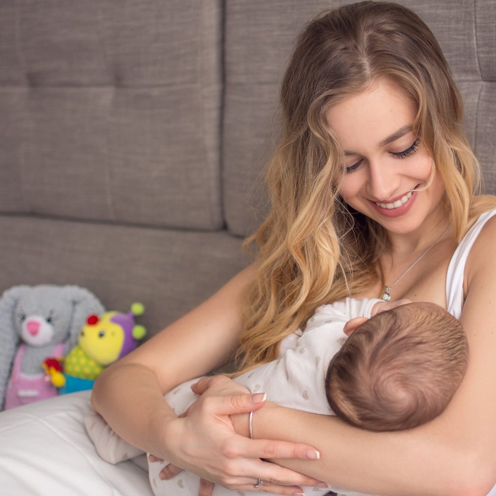 Mother cradling her baby while breastfeeding