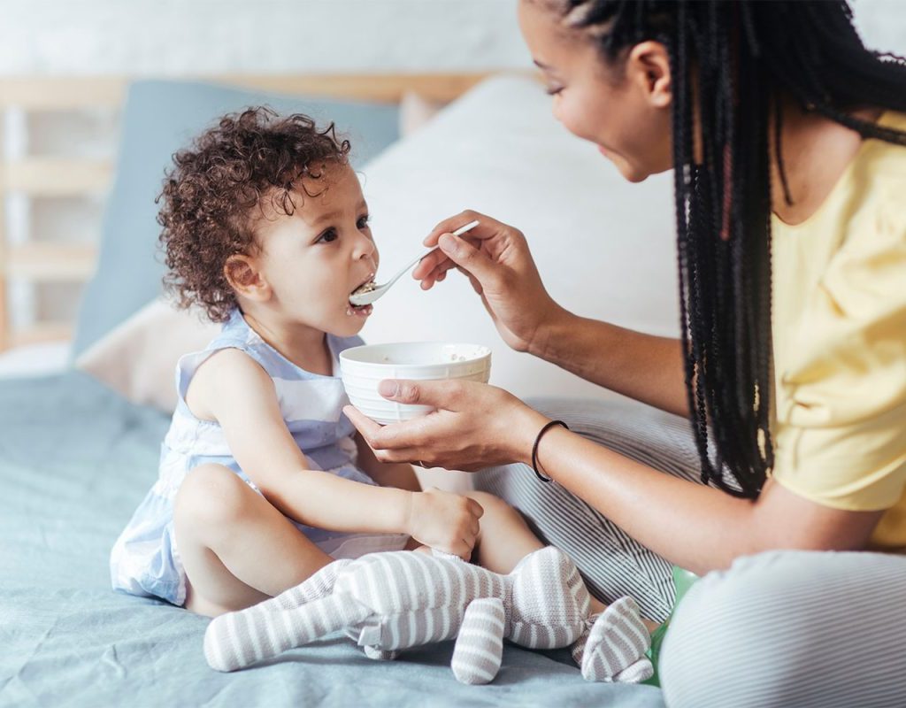 A mother feeding food to her child.