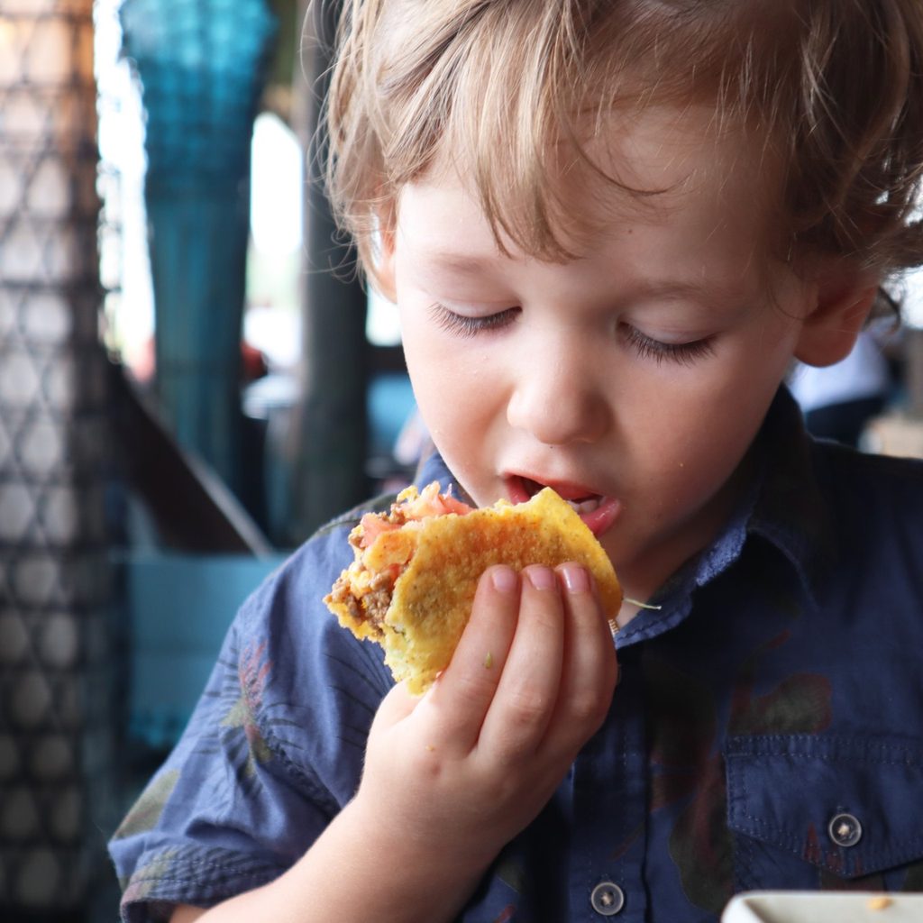 Young boy eating a taco
