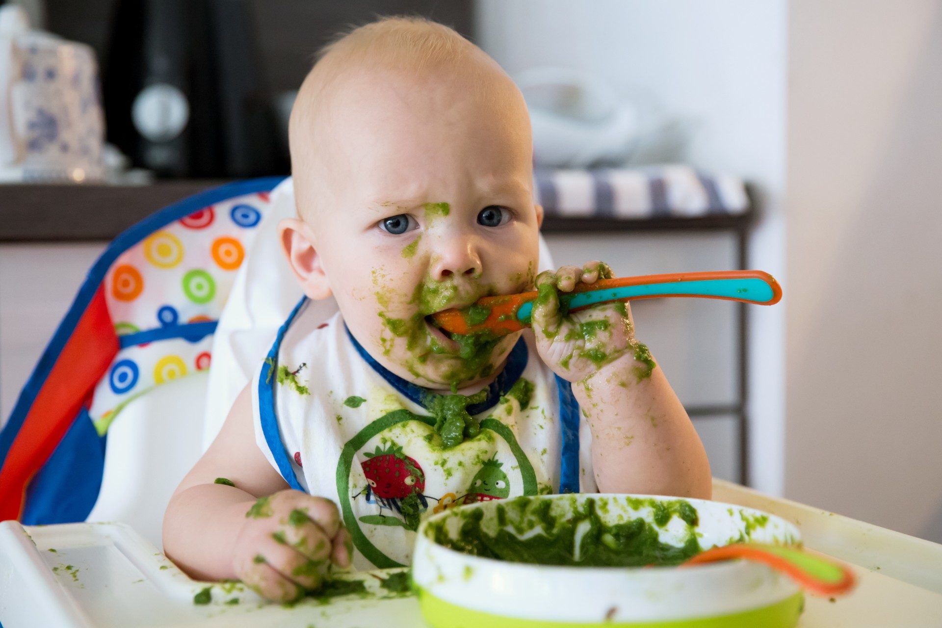 Baby making a mess while eating solid food
