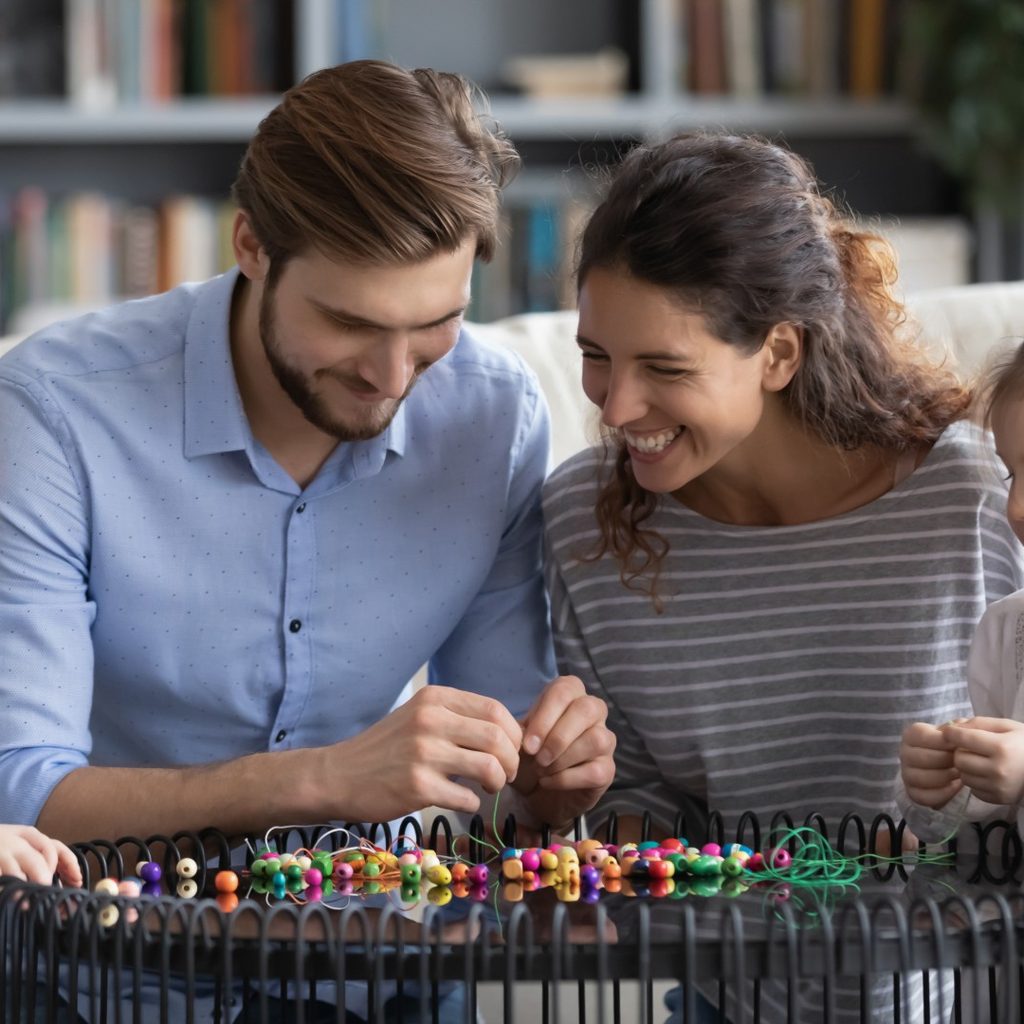 Young parents making crafts with two daughters