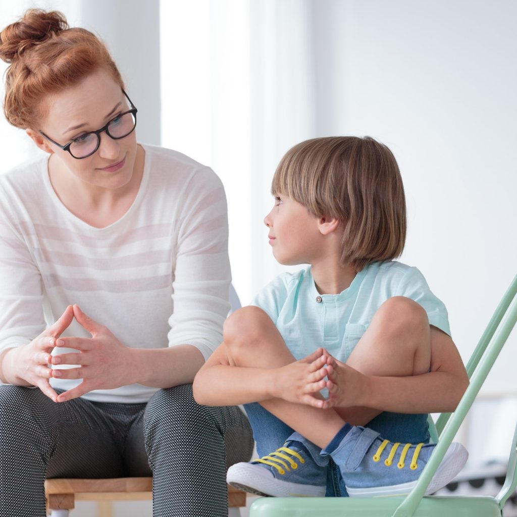 Mother talking with young son in living room