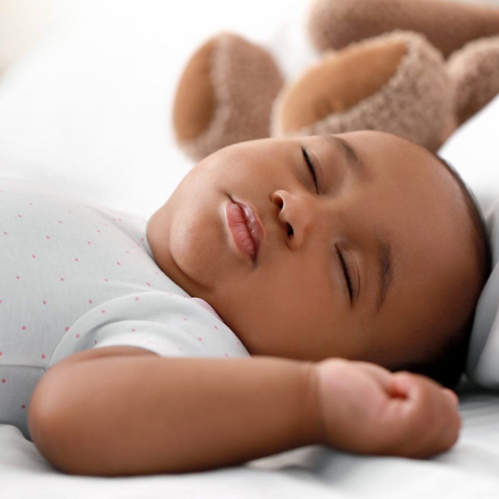 Infant boy sleeping on bed