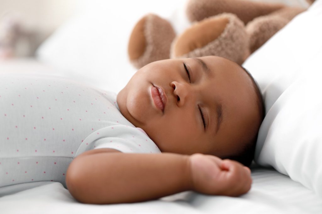 Infant boy sleeping on bed