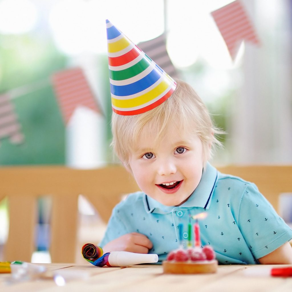 Happy boy with hat at a birthday party