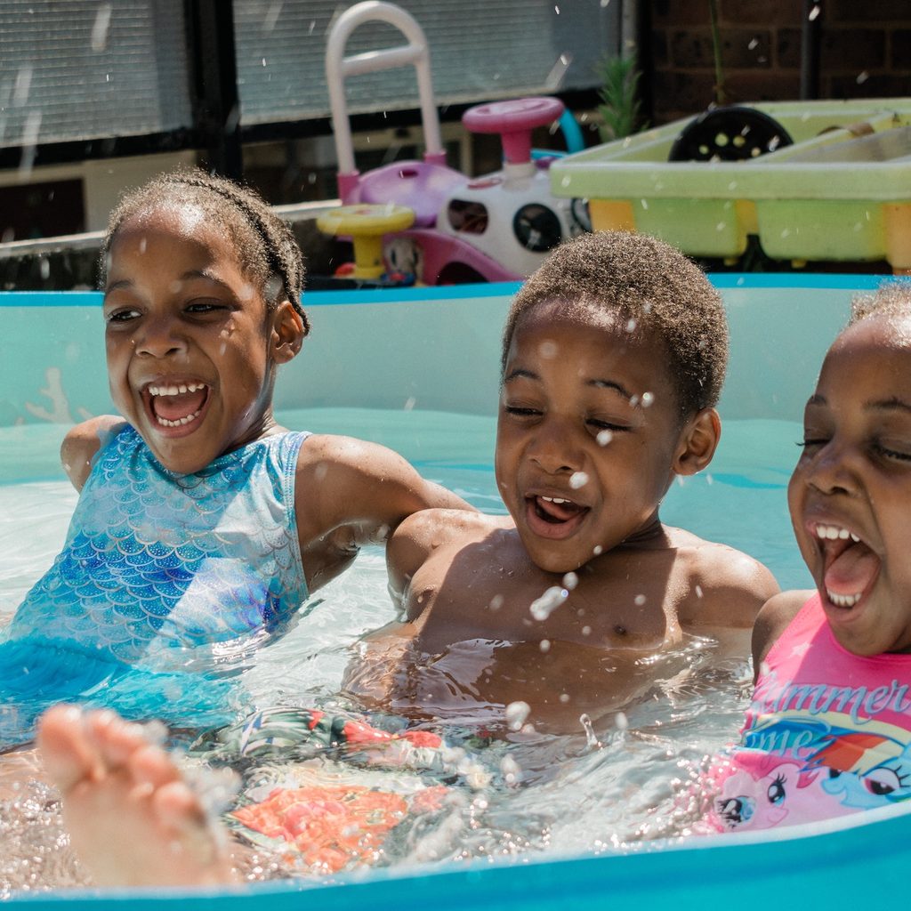 Three kids laughing in pool