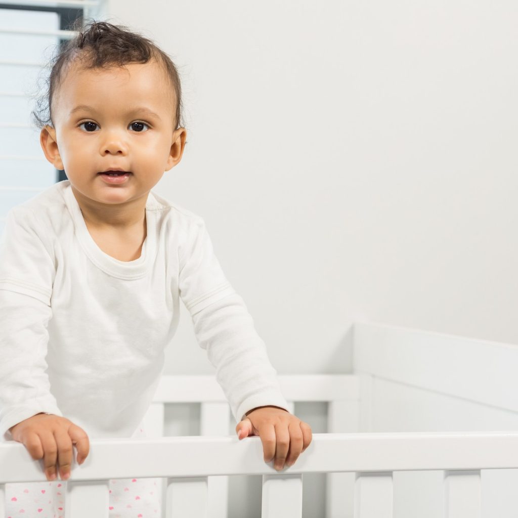 Toddler standing in his crib