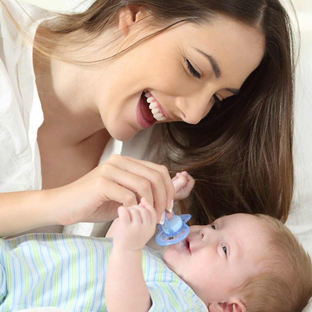 Mother holding a binky with son