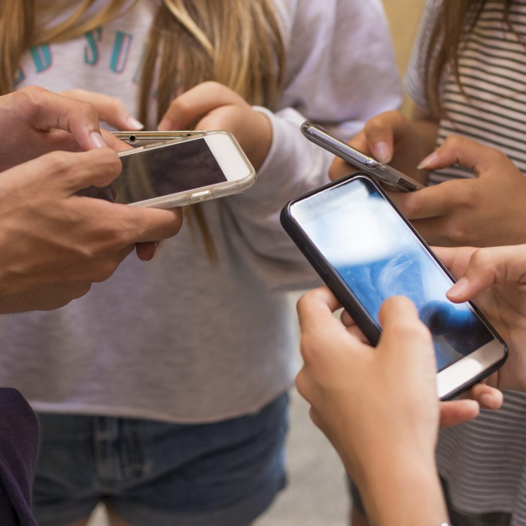 Group of teens using smartphones