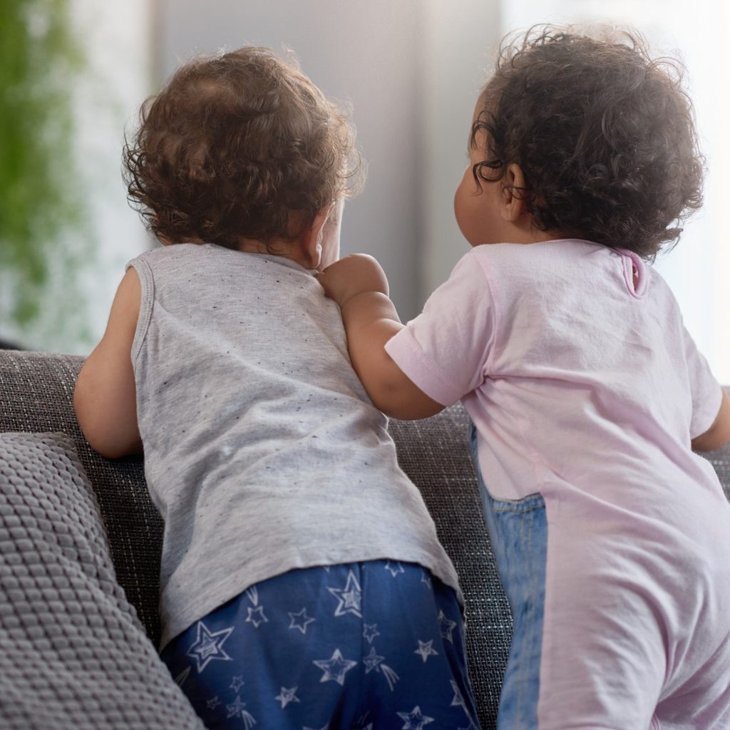 Boy and girl toddlers sitting on a couch