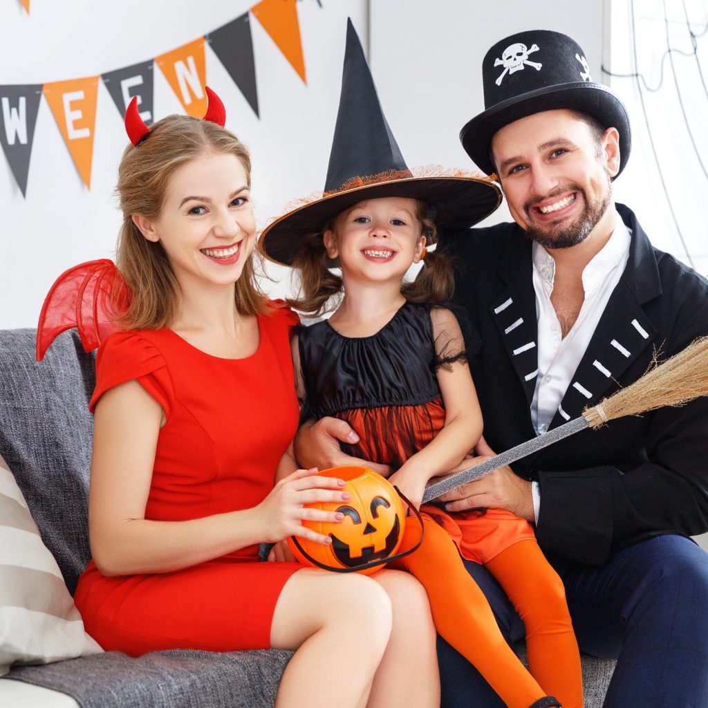 Mother and father with daughter in Halloween costumes