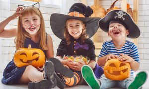three kids laughing and wearing costumes