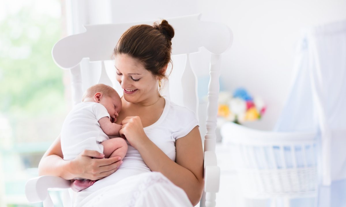 Mother holding baby in nursery