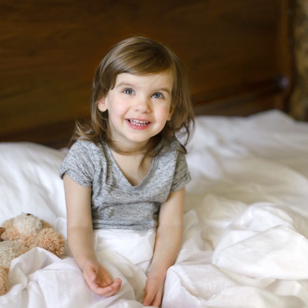 Young girl sitting up in bed