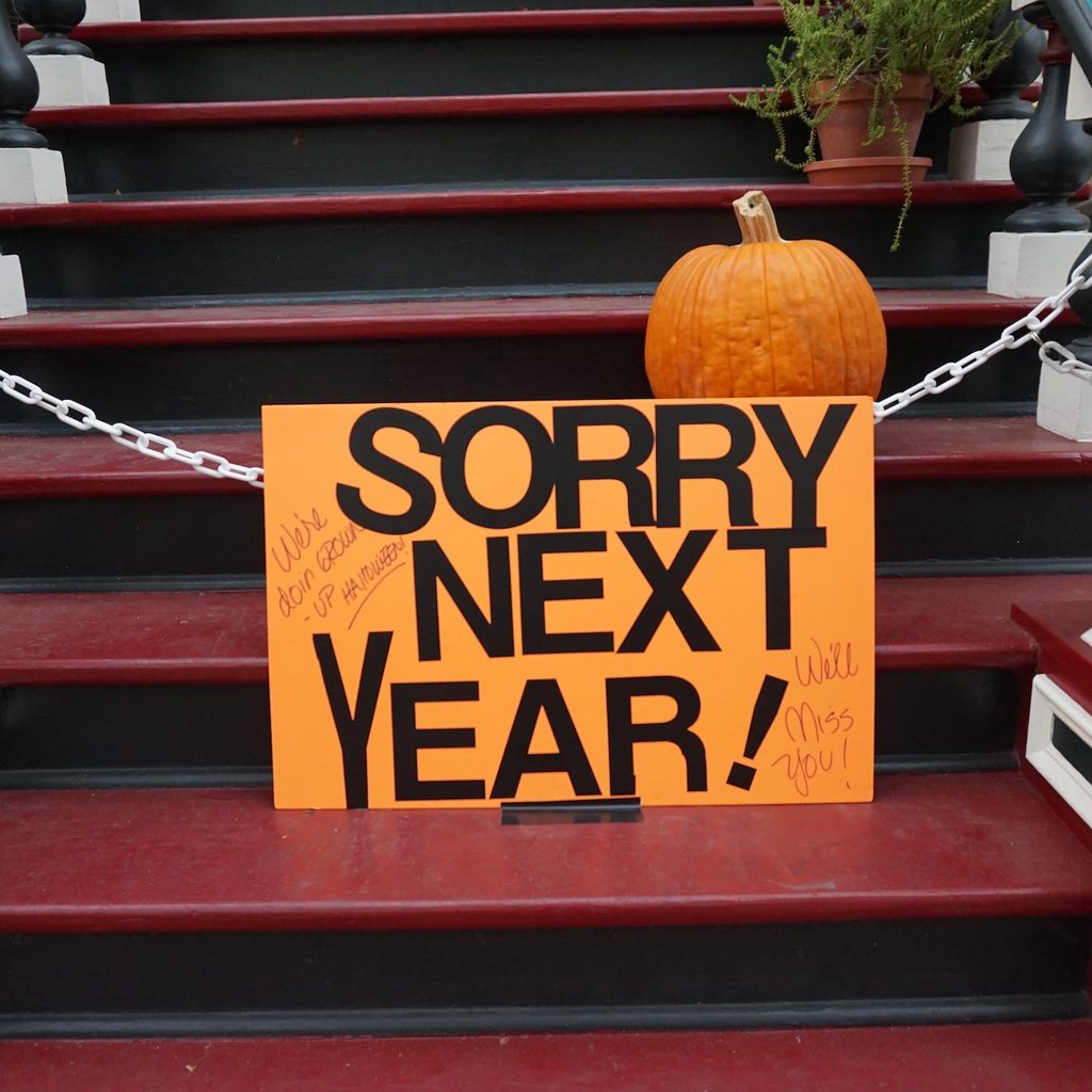 sorry next year sign with chain on doorstep on Halloween