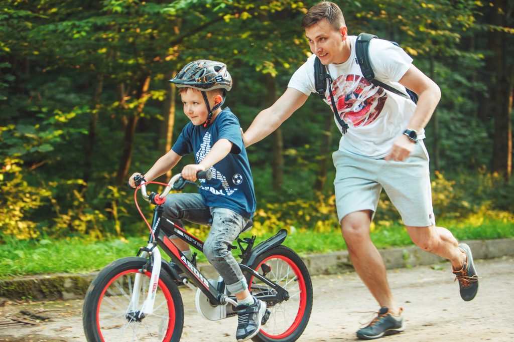 Dad teaching son ride a bike