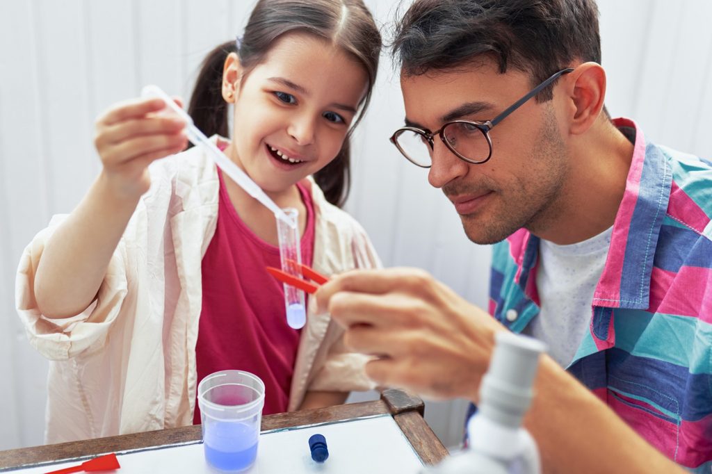 Dad and daughter using toy experiment tools