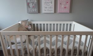 A crib with nursery decor hanging above it