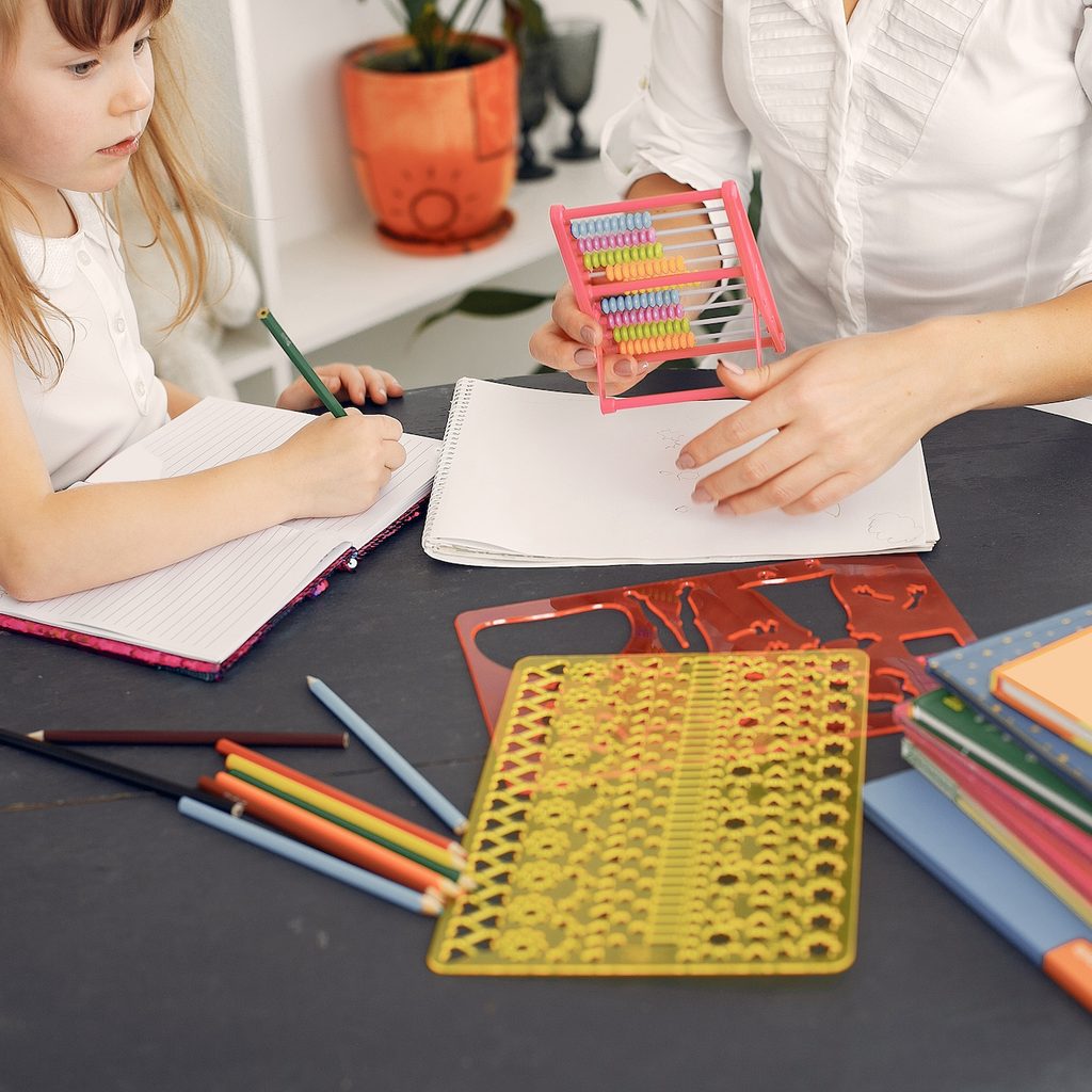 child learning to count at table with schoolwork