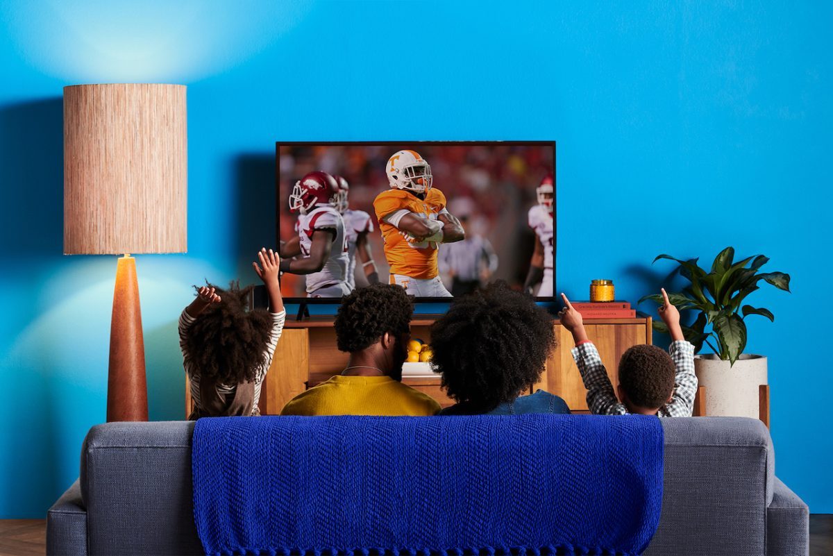 Family watches sling TV together on couch