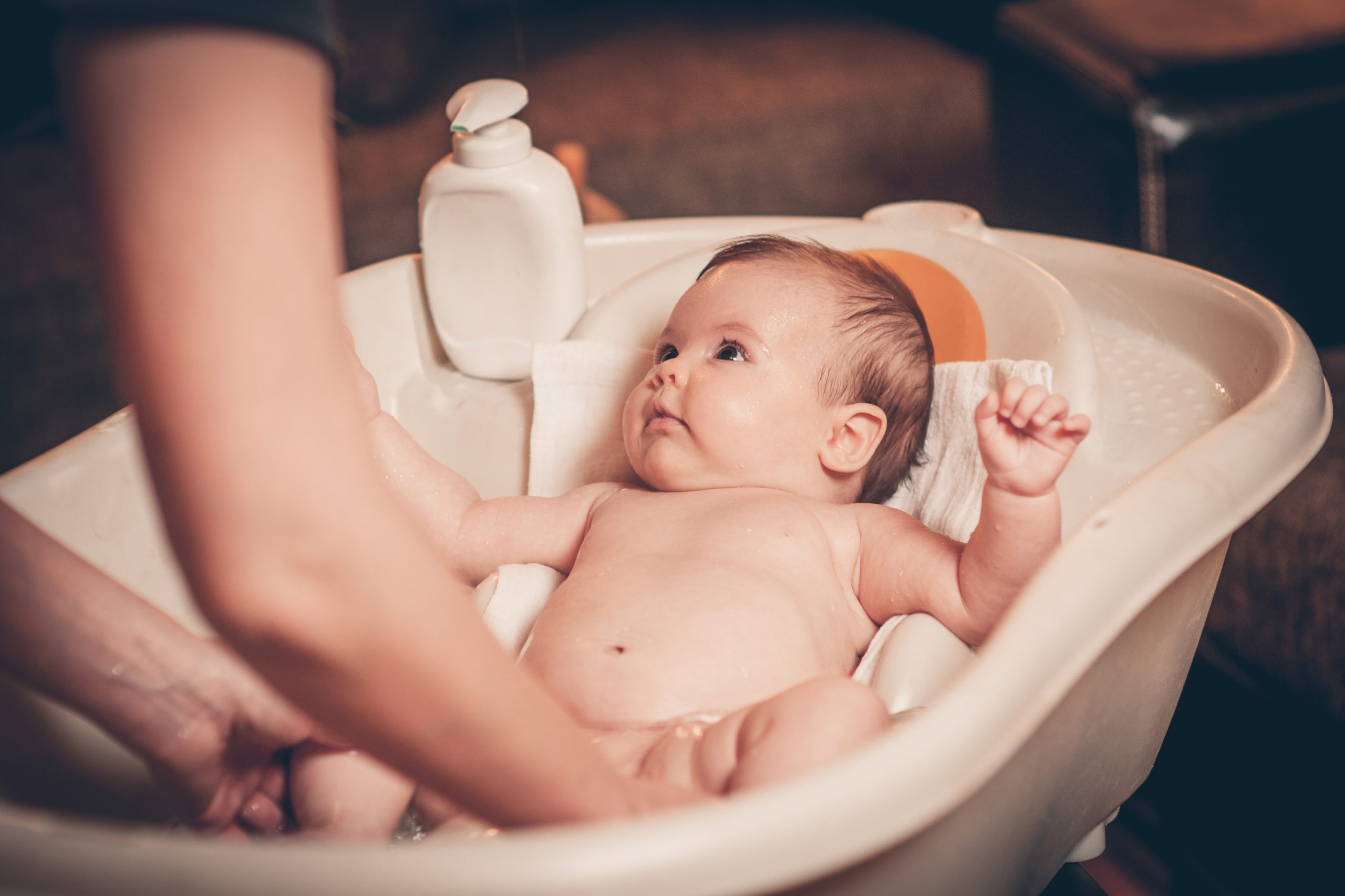 Baby being bathed in convertible-style tub