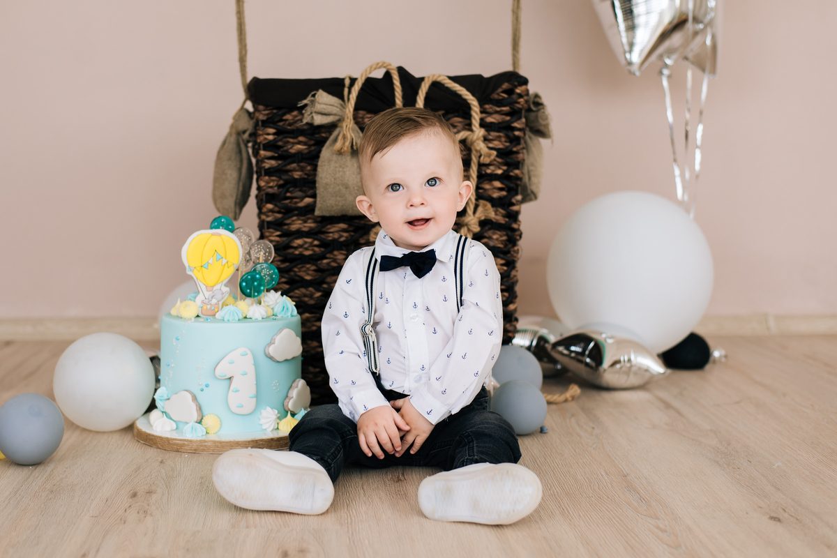 Baby boy surrounded by balloons on first birthday