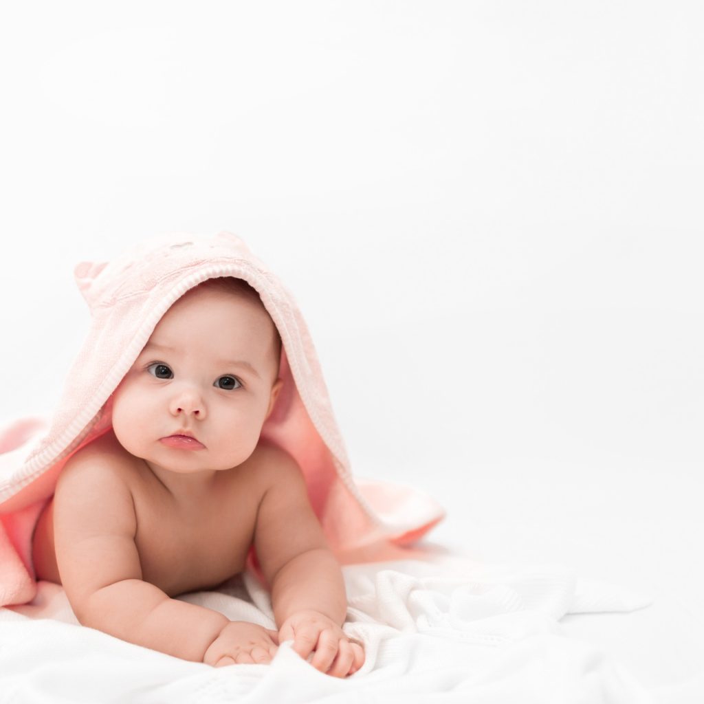 Baby girl after her bath in a hooded towel.
