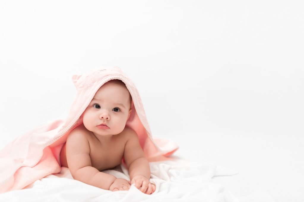 Baby girl after her bath in a hooded towel.