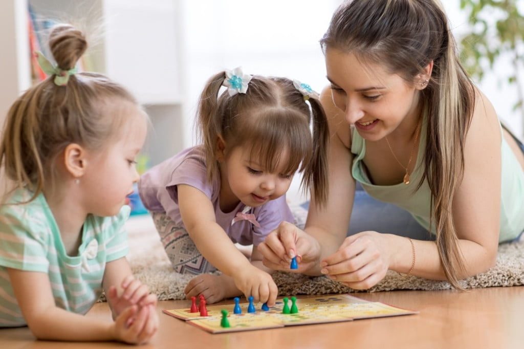 Woman and toddlers playing board game