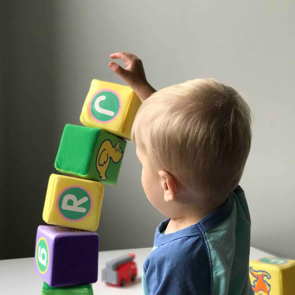 A toddler boy playing with some blocks